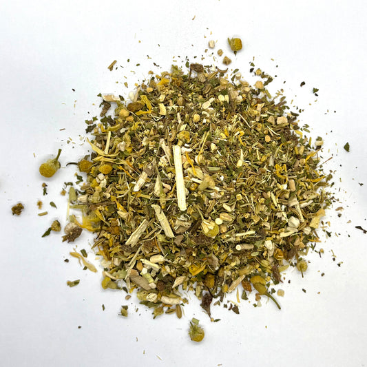 A mixture of dried herbs and flowers, including spearmint, fennel, chamomile, and ginger, indicative of a herbal tea blend.