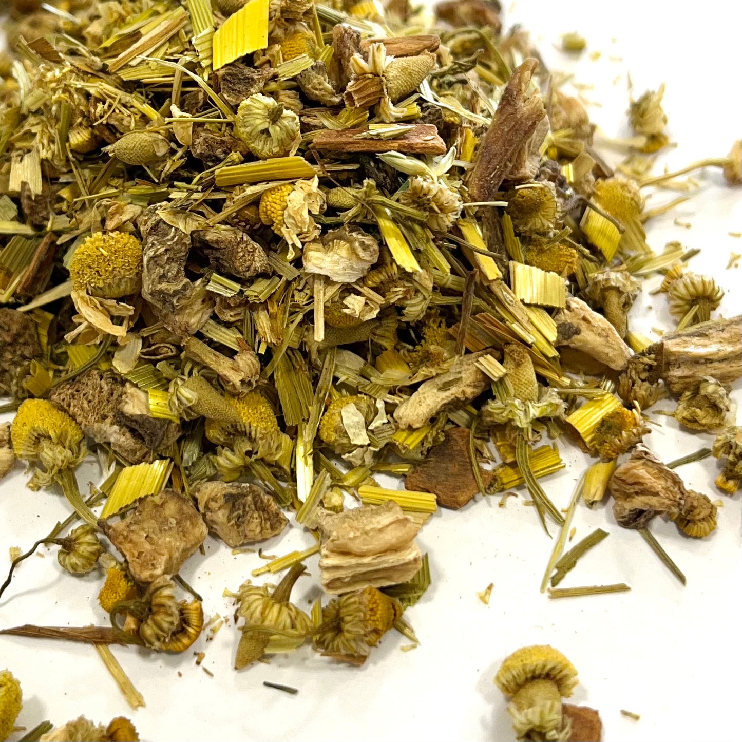 A close-up image of dried herbal tea leaves and pieces, including oat straw, burdock root, chamomile flowers, chicory root, and cinnamon pieces.
