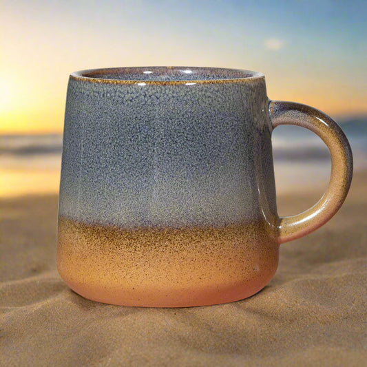 Ceramic mug with gradient blue to brown color on a white background